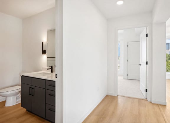 A bathroom with a toilet, sink, and cabinet.