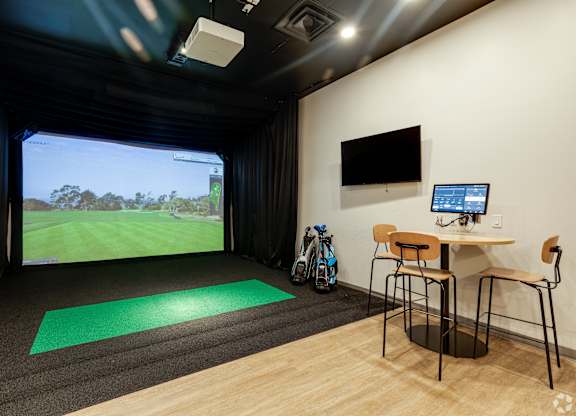 A room with a green mat on the floor and a bike leaning against the wall.