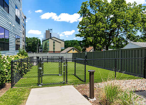 A black metal fence surrounds a green lawn.