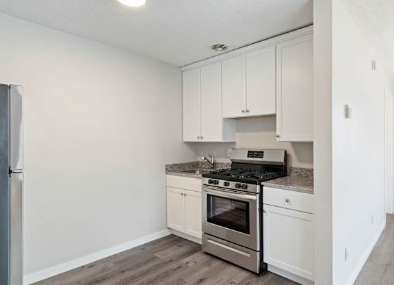 A kitchen with white cabinets and stainless steel appliances.