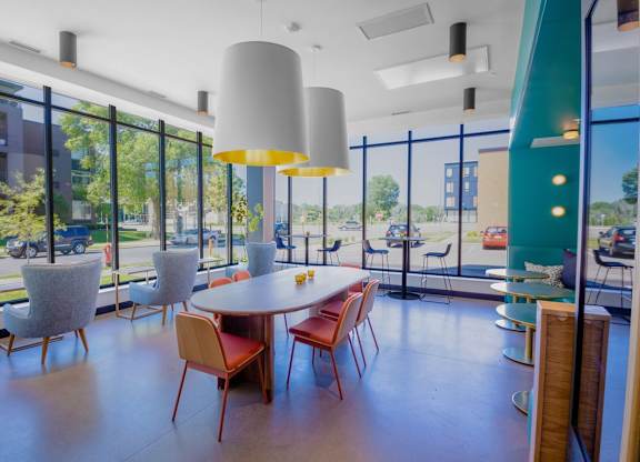 A room with a table and chairs with a view of the outside.