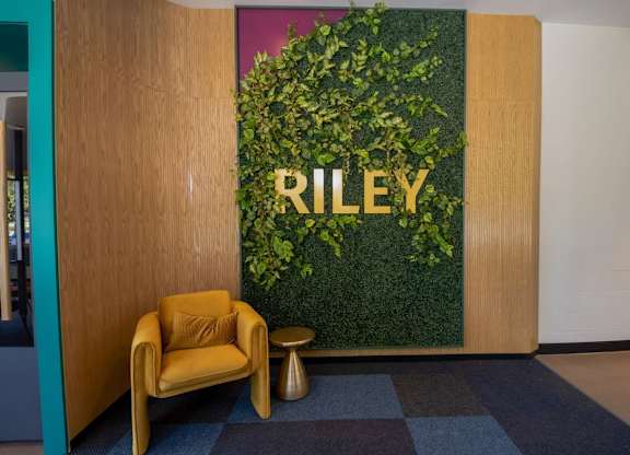 A green plant wall with the word RILEY on it.