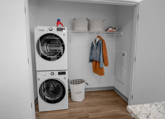 A small laundry room with a washer and dryer stacked on top of each other.
