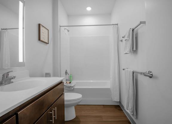 A white bathroom with a toilet, sink, and bathtub.