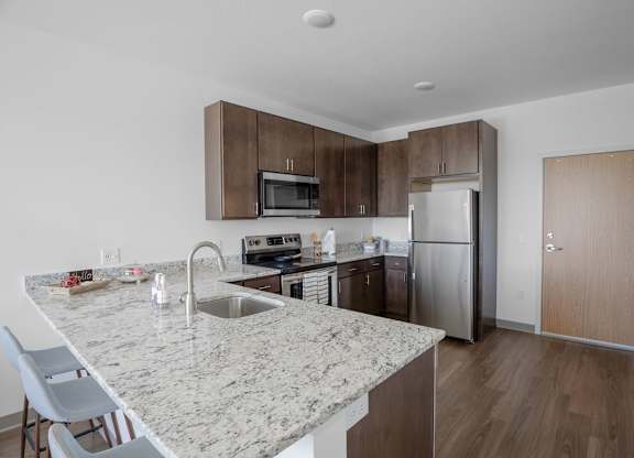 A kitchen with a marble countertop and stainless steel appliances.