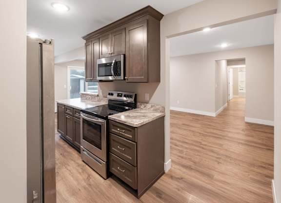 A kitchen with brown cabinets and a stainless steel refrigerator.