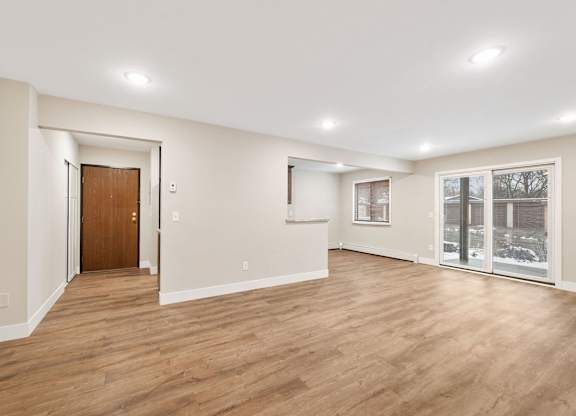 A room with wooden floors and a brown door.