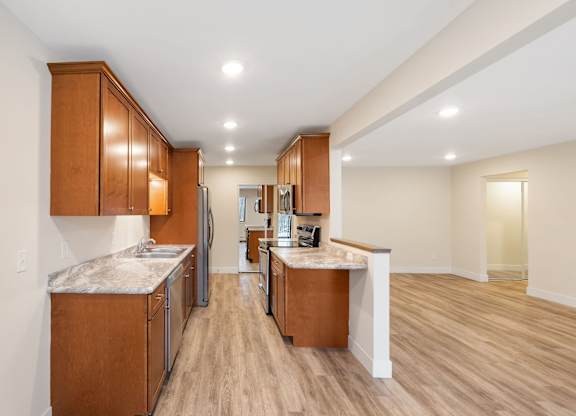 A kitchen with wooden cabinets and a marble countertop.