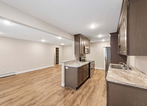 A kitchen with wooden floors and a marble countertop.