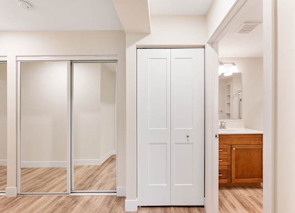 A white bathroom with a white cabinet and a white sink.