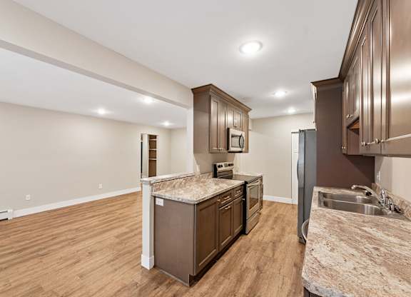 A kitchen with brown cabinets and a granite countertop.