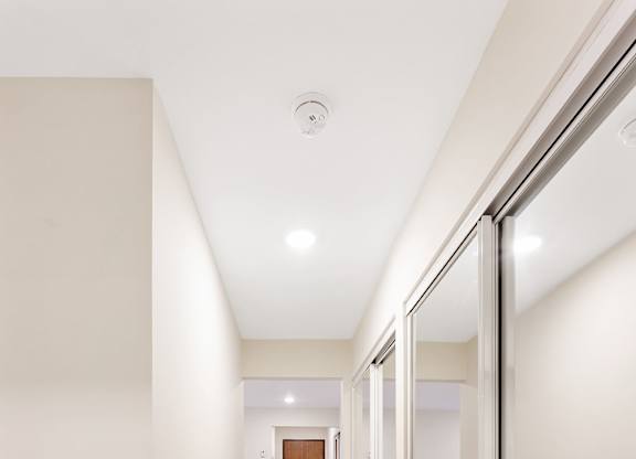 A long hallway with a wooden floor and white walls.