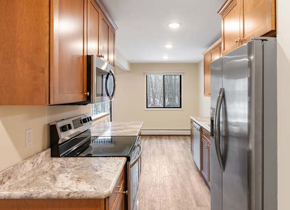 A kitchen with wooden cabinets and a refrigerator.