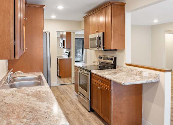 A kitchen with wooden cabinets and a marble countertop.