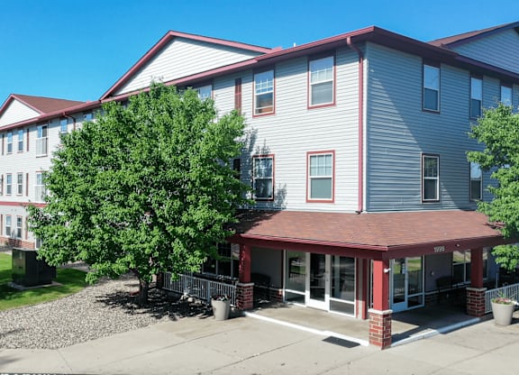 A building with a red roof and a tree in front of it.