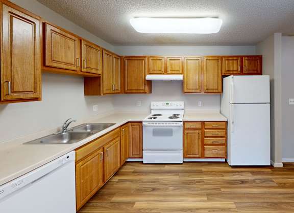 A kitchen with wooden cabinets and white appliances.