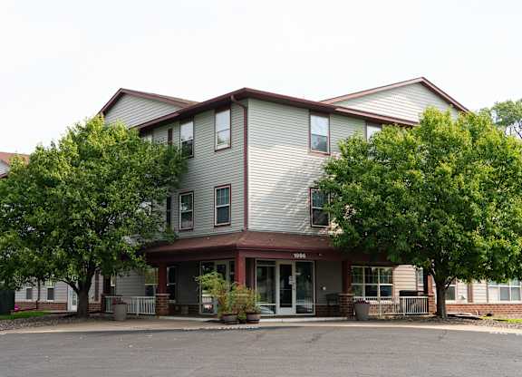 A two-story apartment building with a parking lot in front.