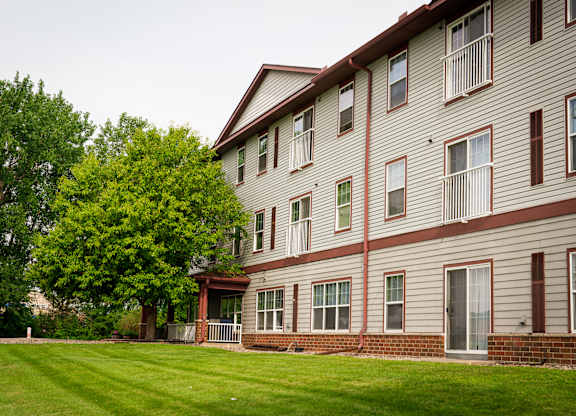 A large building with a green lawn in front.