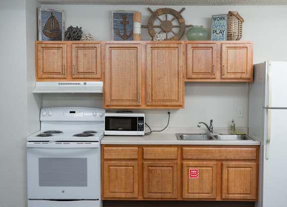 A kitchen with wooden cabinets and a white refrigerator.