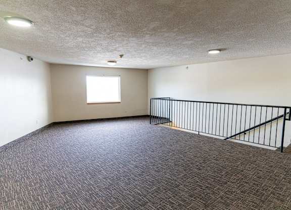 A room with a carpeted floor and a window.