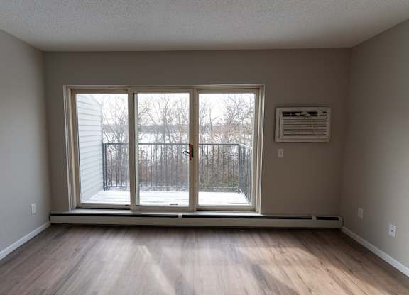 A room with a sliding glass door leading to a snowy outdoor area.