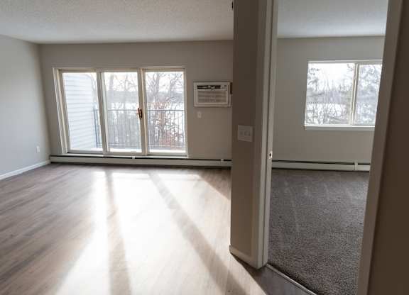 A room with a carpeted floor and a sliding glass door.
