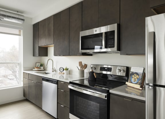 a kitchen with dark wood cabinets and stainless steel appliances