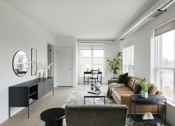 a living room with white walls and a brown leather couch