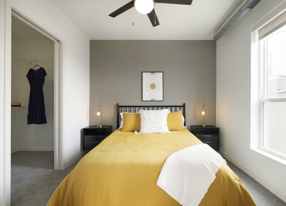 a bedroom with a large yellow bed and two windows