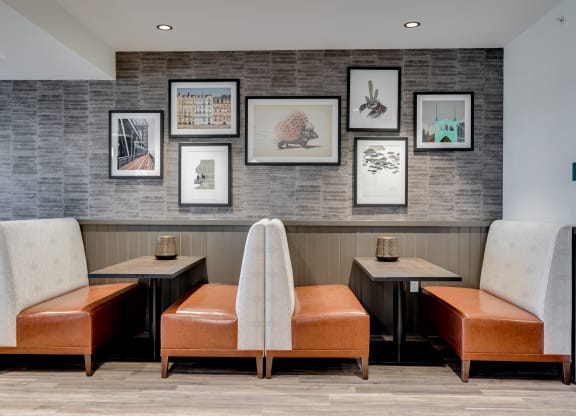 a seating area with chairs and pictures on the wall