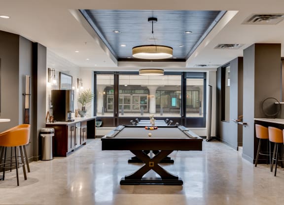 a game room with a pool table and a bar