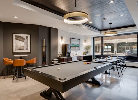 clubhouse with pool table at the district flats apartments in lenexa