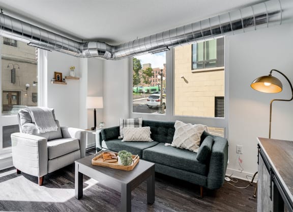 a living room with a couch and a chair in front of a window
