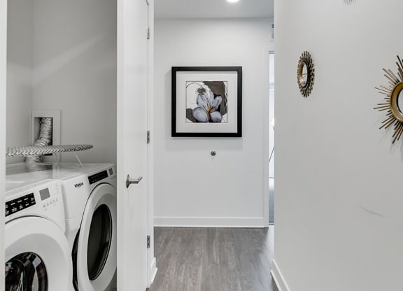 a white laundry room with a washing machine and a dryer