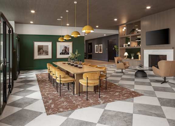 A dining room with a checkered floor and a long table with chairs.