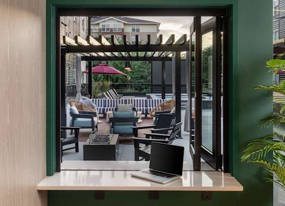 Two stools are placed in front of a window with a view of a patio.