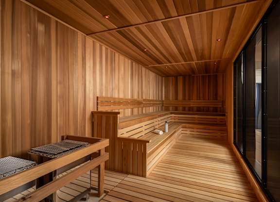 A wooden sauna with benches and a table.