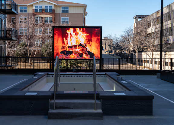 A billboard with a fiery image is displayed in an outdoor setting.