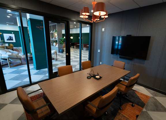 A conference room with a large table and chairs.
