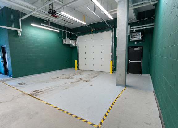 A large empty room with a white floor and green walls.