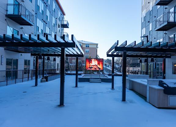 A snow-covered outdoor area with a red sign in the background.