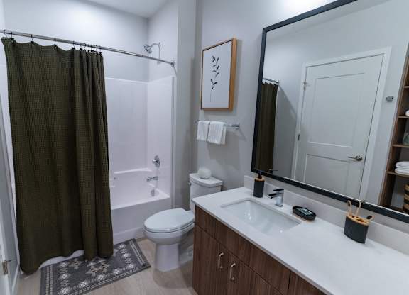A bathroom with a white sink and a white toilet.