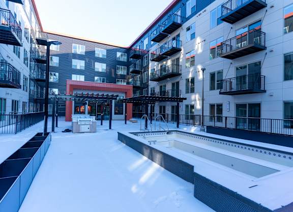 A snow-covered courtyard surrounded by apartment buildings.
