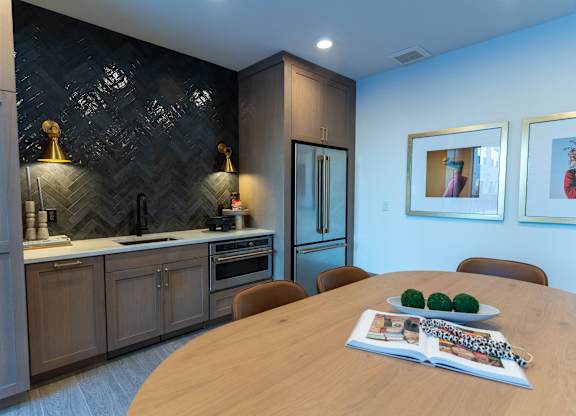 A modern kitchen with a wooden table and chairs.