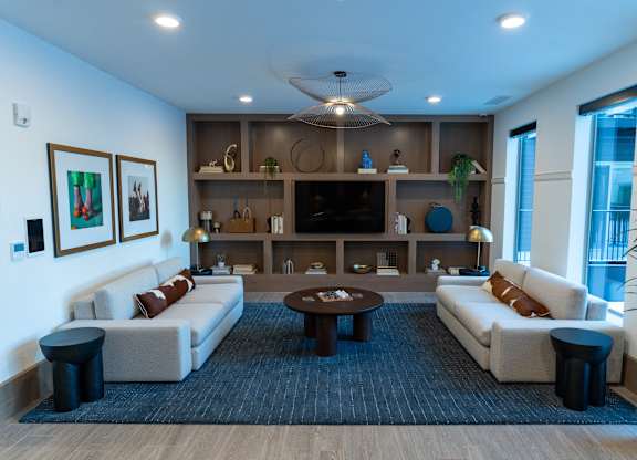 A modern living room with a large sofa set, a coffee table, and a TV.