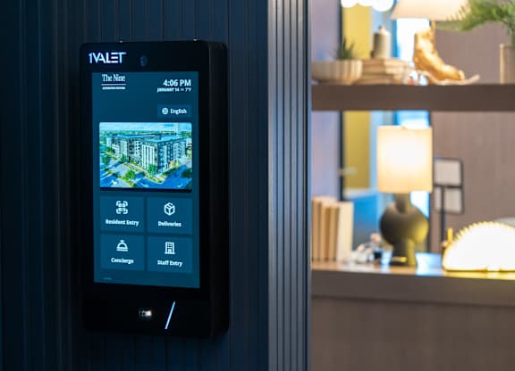 A tablet displaying a hotel room with options for housekeeping, deliveries, concierge, and staff entry.