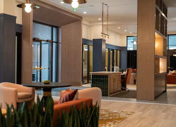 A modern office lobby with a reception desk and seating area.