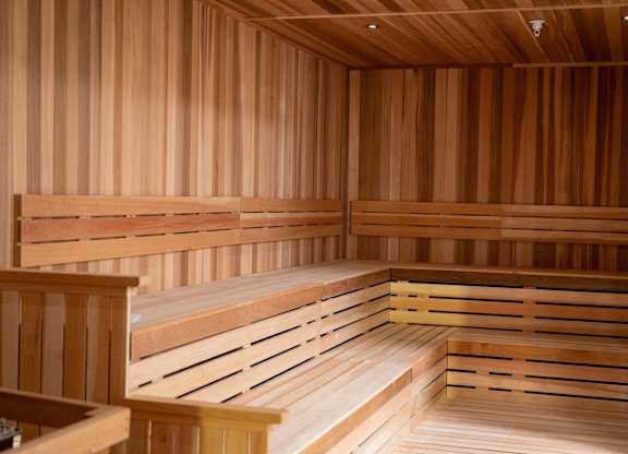 A wooden sauna with benches and a warm glow.