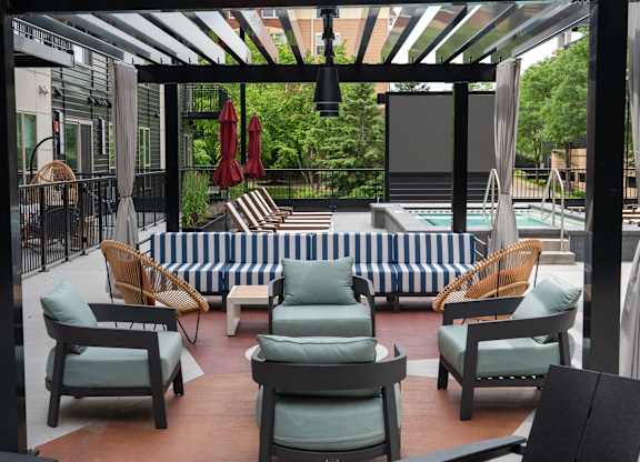 A patio with a striped couch and chairs.