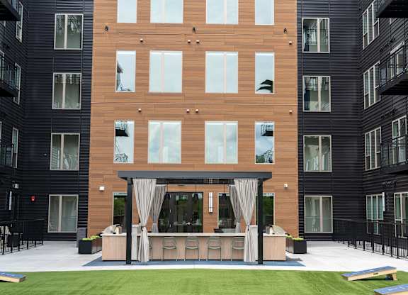 A modern building with a balcony and a patio area.